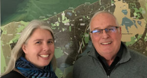 Executive Director Amy Henderson and Board President Hal Minis in front of Brewster property map