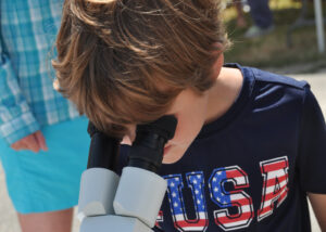 Boy looking through microscope at Brewster Conservation Day